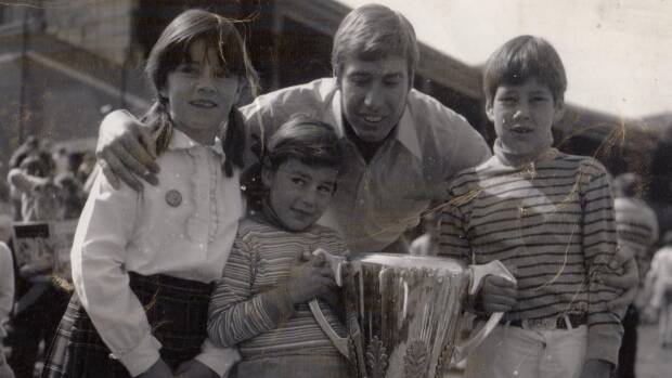 Caroline Wilson with sister Amelia, brother Will, Bill Barrot and the Richmond 1969 premiership cup. Photo: Supplied

