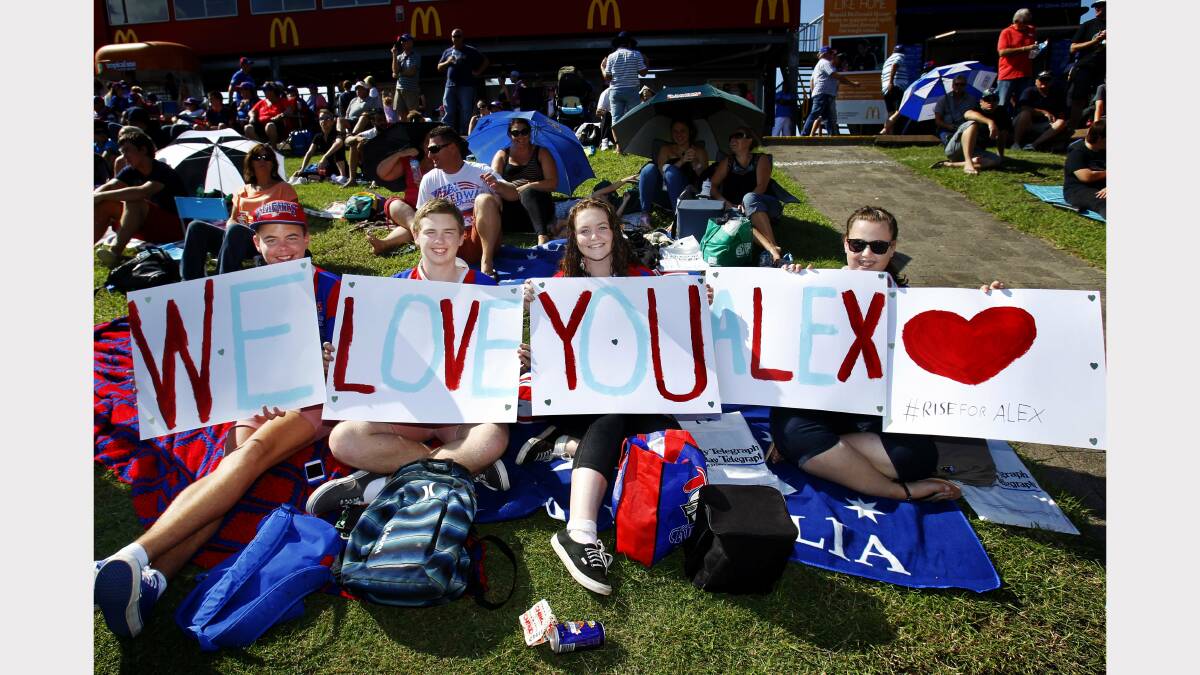 Knights fans Hayden Paul of Tarro, Brock Bungard of Beresfield, Josie Watt of Maitland, and Shawnee Lowbridge of Tarro with a message of support for critically injured Knights player Alex McKinnon.   Pic by MAX MASON-HUBERS 