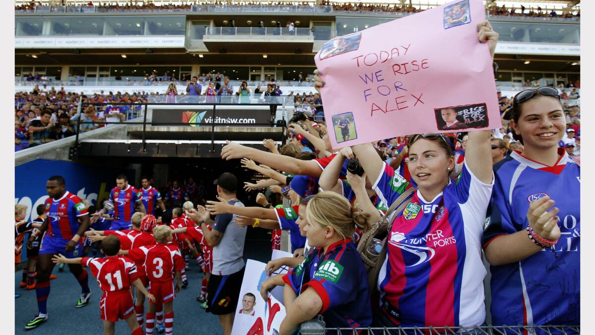 Knights fans Sarah & Emma Gardner of Maryland with a message of support for critically injured Knights player Alex McKinnon. Pictured at the entrance to the tunnel as the Newcastle Knights run out. Photo: MAX MASON-HUBERS