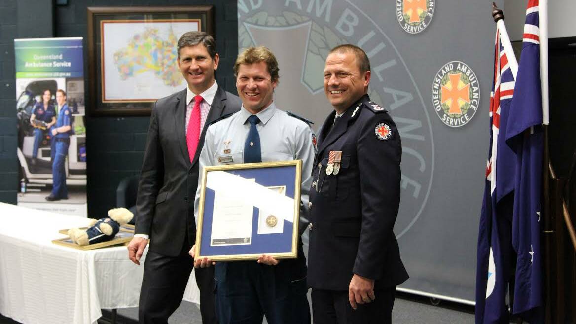  State Health Minister Lawrence Springborg and QAS Commissioner Russell Bowles present Karumba’s paramedic Andrew Lowndes with his award in a ceremony in Brisbane. 