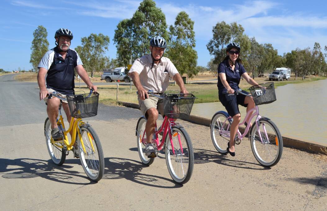 CAMP LIFE: Camp host Felix Uscinas, grey nomad Ray Covill and community services team leader Jade Lyons cycling at the Julia Creek RV campsite.