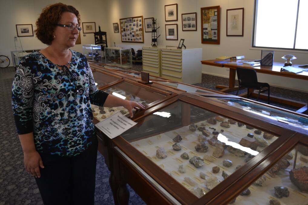 Relief tourism officer Anita Morris examines the display case at Cloncurry Unearthed, where 14 minerals were stolen in daylight hours.