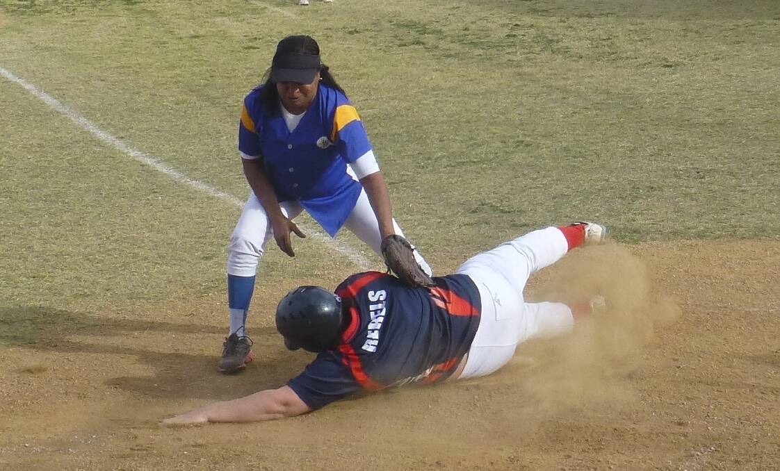 SAFE: Andy Bellamy (Wanderers Blue) goes in for the tag as Megan Protheroe (Rebels Red) slides safely into home plate.