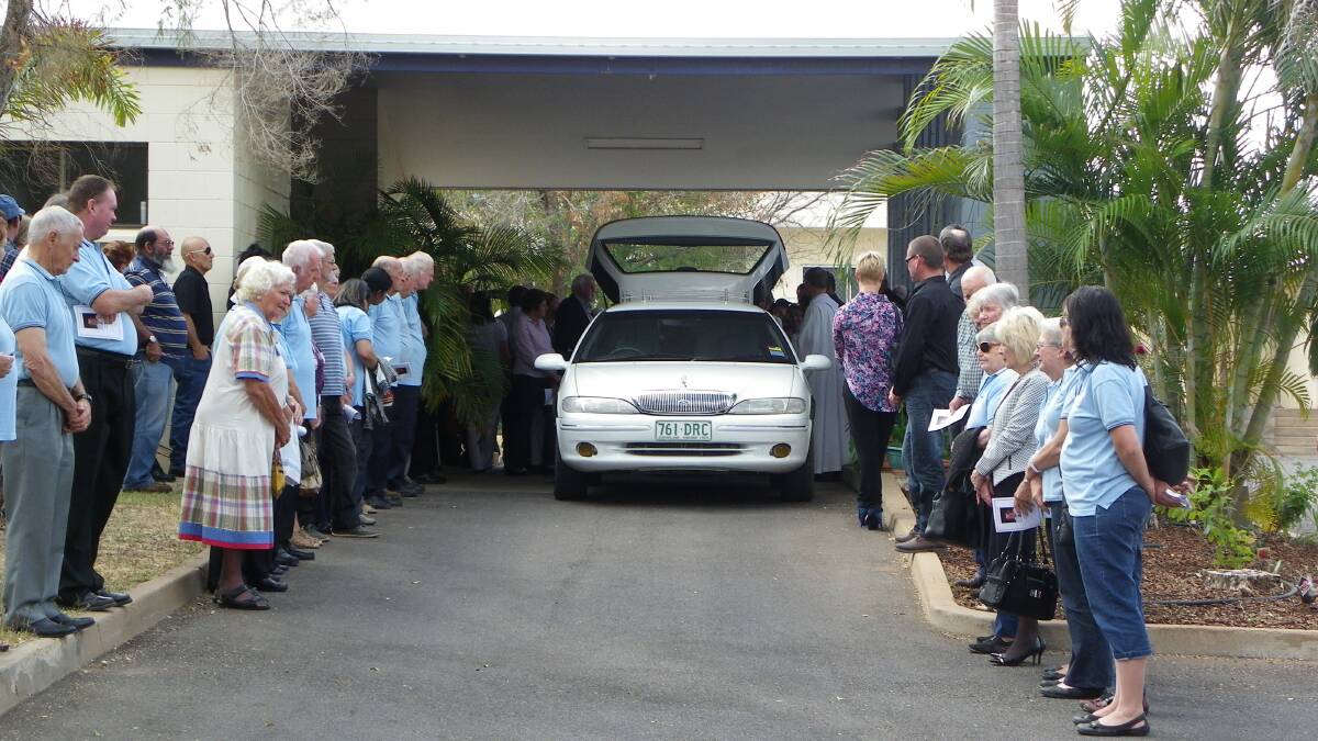 FINAL  JOURNEY:  Meals on Wheels members, friends and family form a guard of honour for David Neville’s final journey after his funeral service last Friday at Good Shepherd Church.