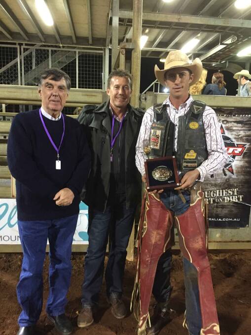 Mount Isa Mayor Tony McGrady and Major David Hopgood present a trophy to PBR Australia Mount Isa champion Ben Seeds.