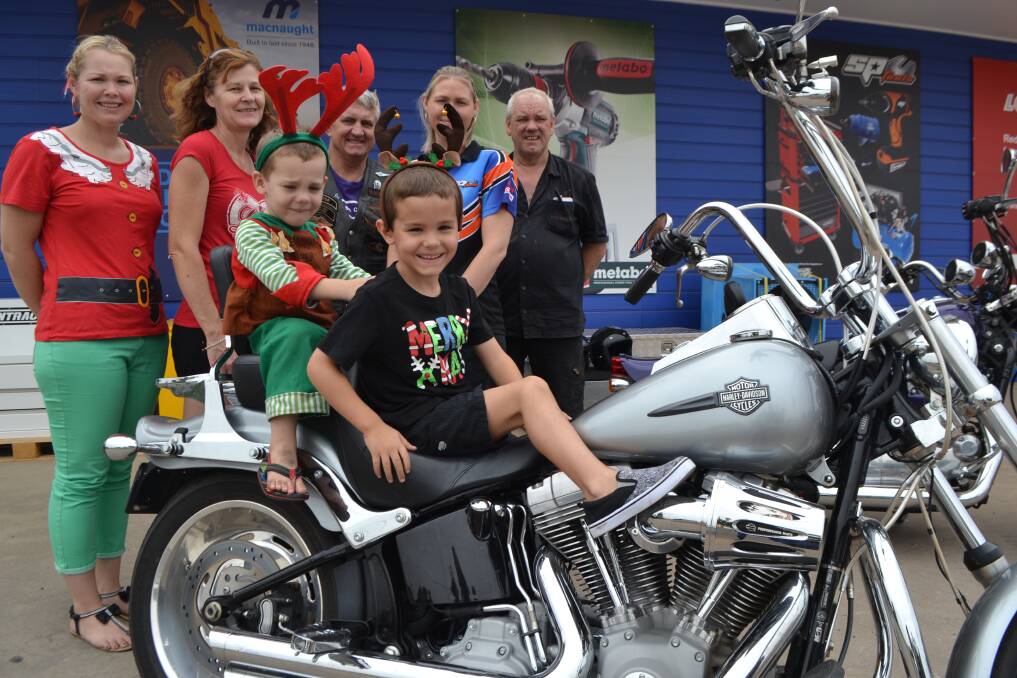 TRAVELLING IN STYLE: Xander Crowther, 5, on a Harley with his brother Braxton, 3. Also pictured are Mount Isa Christmas Lights Tour organiser Megan Crowther, Cheryl Moloney, Justene Cameron, of BOSS Shop, HOGS director Tony Moloney, and Mount Isa Harley-Davidson store owner Mark Strain. 