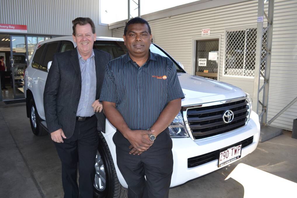 ASTONISHED: Narendra Paul (right) is excited to receive a Toyota Landcruiser 200 series GXL  from Bell and Moir Toyota dealer principal Lee Pulman after winning the 2014 Mount Isa Rotary Rodeo Art Union raffle.