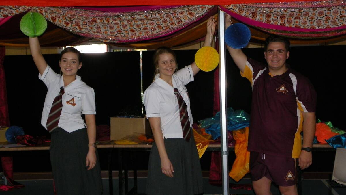HELPING HANDS:  Year 12 students  Emma Johnstone, Danae  Giardina and Ryan Cullis were among the army of volunteers helping set up the hall yesterday for the Bollywood Ball.
