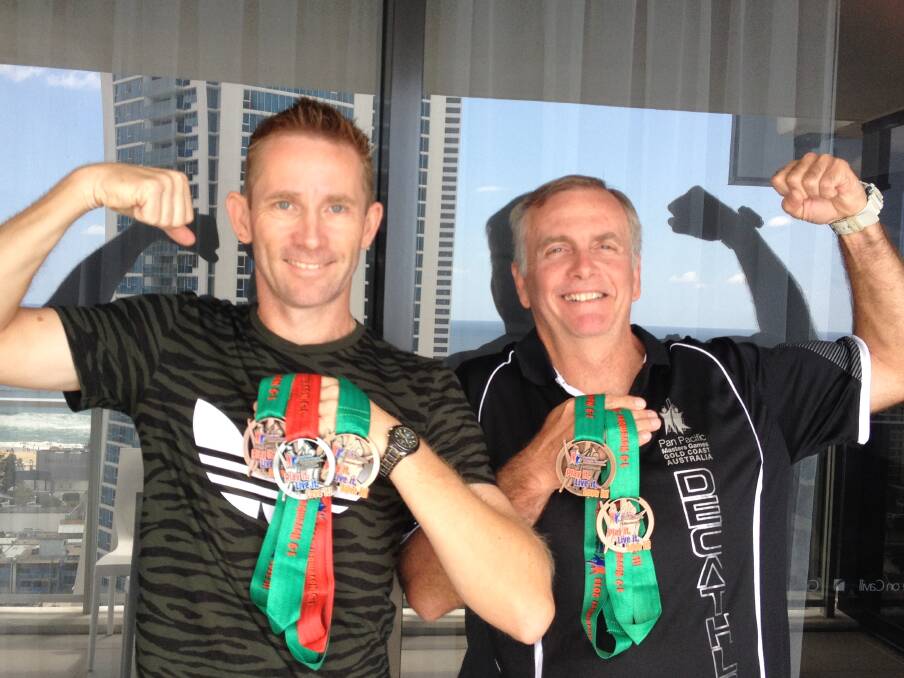 Mount Isa Athletic Club president and award nominee David Scott and club coach Ken Dickson show off their medals from the 2014 Pan Pacific Masters Games.