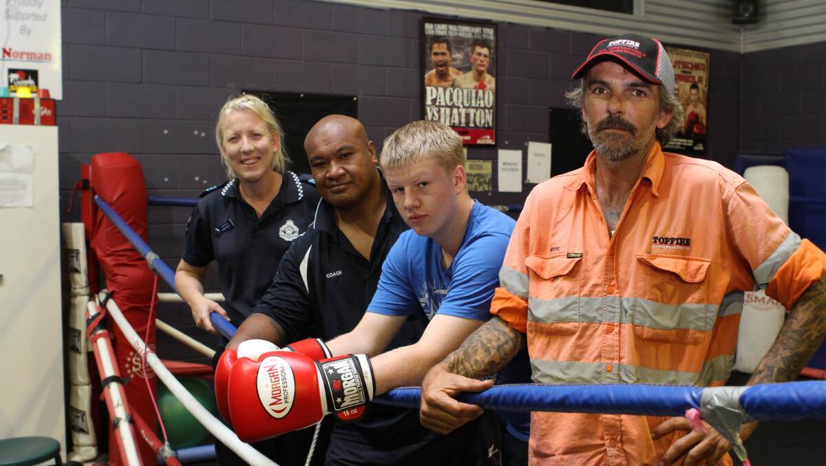 FIGHT NIGHT: Sergeant Gina Scott and PCYC boxing coach and police liaison officer Josh Fuimoana, with Trent Jones, 16, and Wade Remington, of Topfire Constructions, at the Mount Isa PCYC. 
