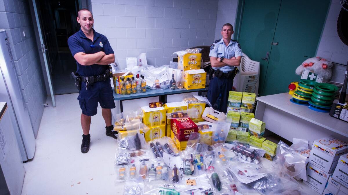 Senior Constable Rowan Treiguts and Senior Constable Philip Newton with items seized by Doomadgee police as part of a recent drug and alcohol blitz.