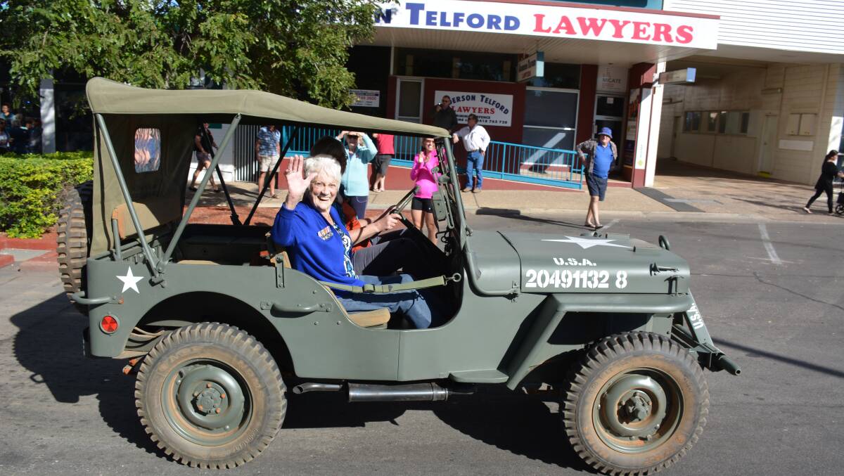 WAVE: Kelly Snow, 95, in a military jeep in Miles Street at the Mount Isa Anzac march on Saturday. 