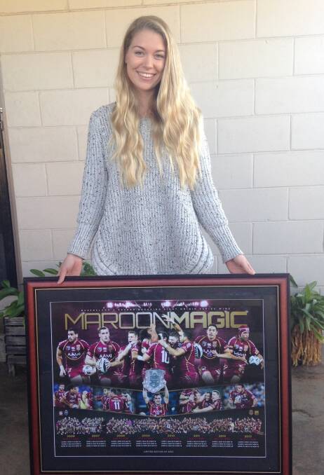 Event organiser Lily Makim holding one of the prizes – framed memorabilia of the Maroons, donated by Frame World. 