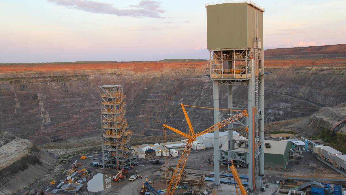 MAMMOTH MOVE: Ernest Henry Mining's 380-tonne sky shaft (left) was constructed 60 metres away from the mine's newly sunk shaft and carefully moved into place under the main head frame (right) this Tuesday.  
- Pictures: Ernest Henry Mining 