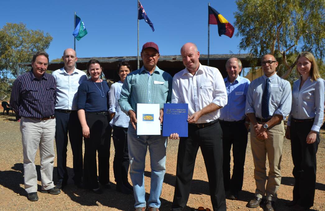 BIG PLANS: Holding the research agreements relating to the development and commercialisation of spinifex fibres are Dugalunji Aboriginal Corporation managing director Colin Saltmere and Professor Darren Martin from the University of Queensland’s Australian Institute for Bioengineering and Nanotechnology. Also visiting the Dugalunji Camp are Professor Paul Memmott, UQ, Phil Nelson, UniQuest, Sue McKell, UQ, Sally Sheldon, Dugalunji Aboriginal Corporation, Professor Peter Gray, UQ, Professor Mark Western, UQ, and Erica Davis, UQ. 