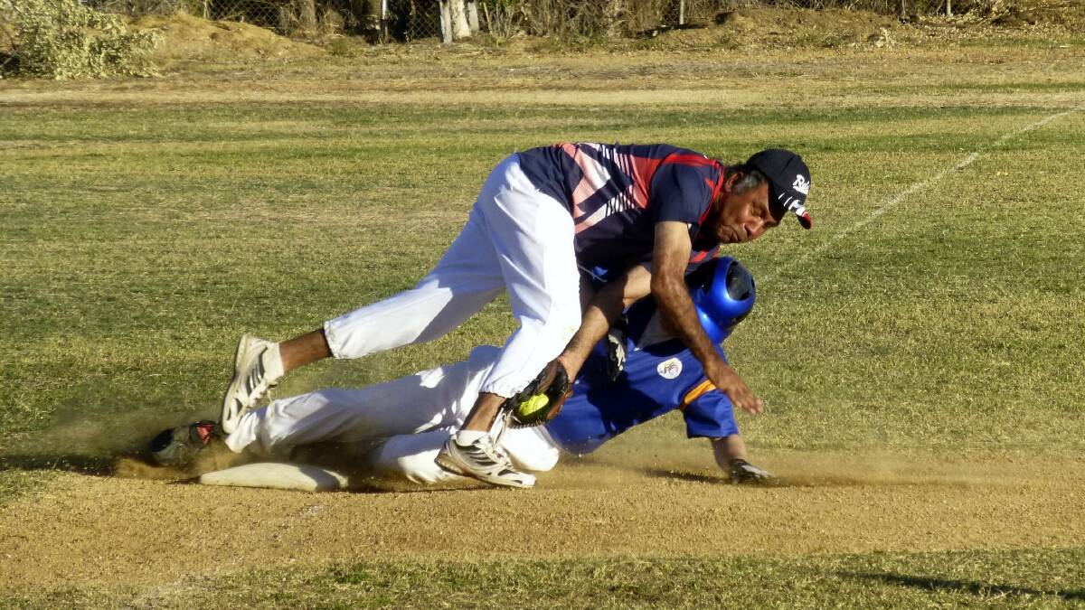 SAFE: A-grade player Jeff Biffin (Rebels) takes a spill as he tries to tag out Jason Wellington (Wanderers) who slides safely into third base.