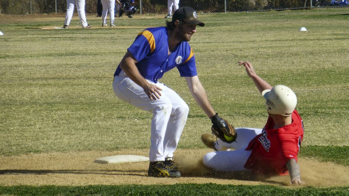 HE’S OUT: A-grade player Ryan Smith (Wanderers) tags out Jayson Morgan (Red Devils) who was sliding into second base.