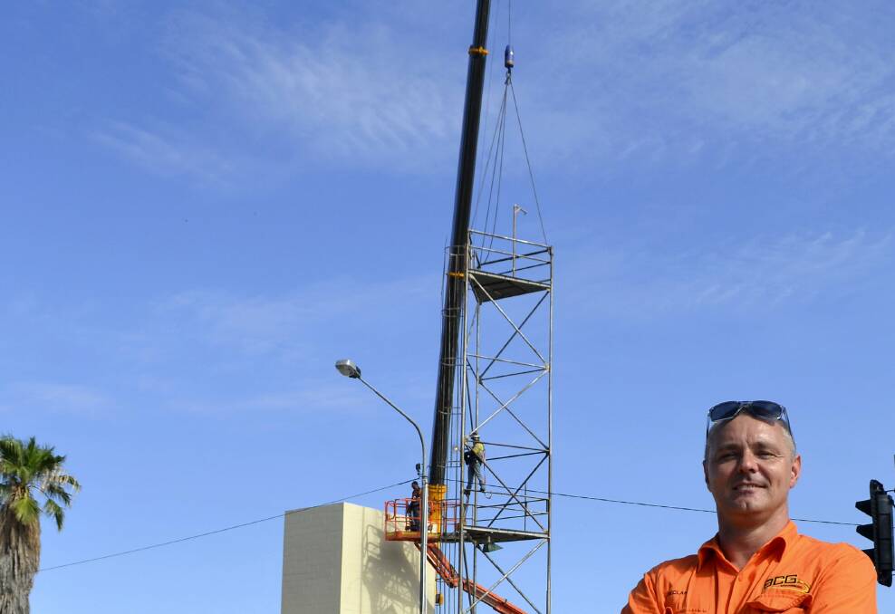 ■DISMANTLED: BCG Engineering site co-ordinator Declan Kearney and employees dismantle the Mount Isa Fire Station’s condemned hose tower.