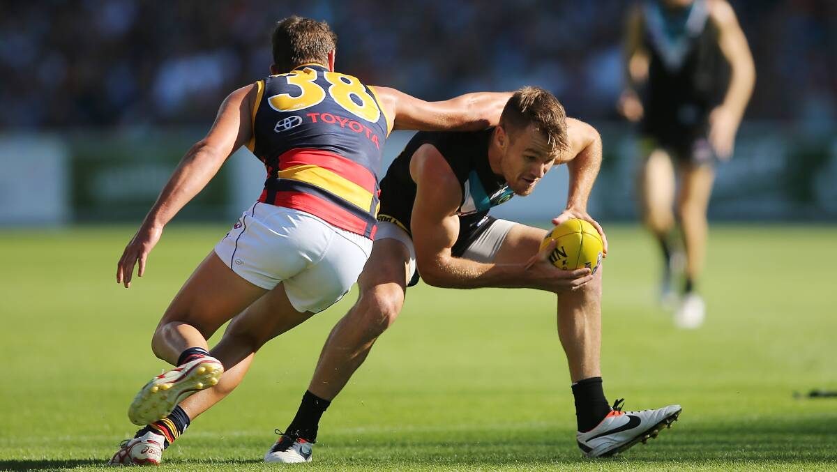 Robbie Gray of the Power evades a tackle by Mitch Grigg of the Crows after kicking a goal during the round two AFL match. Photos: Getty