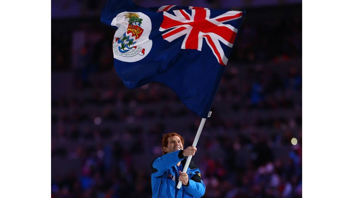 Skier Dow Travers of the Cayman Islands Olympic team carries his country's flag during the Opening Ceremony of the Sochi 2014 Winter Olympics. Picture: Getty