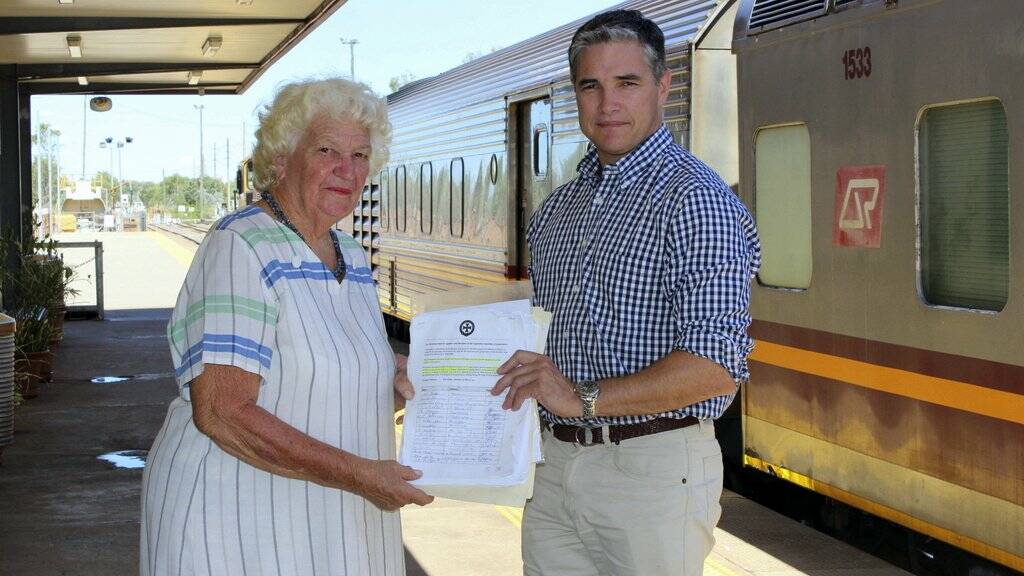 Mount Isa Pensioners Association President Anne Morris presents a petition  to Member for Mount Isa Rob Katter.