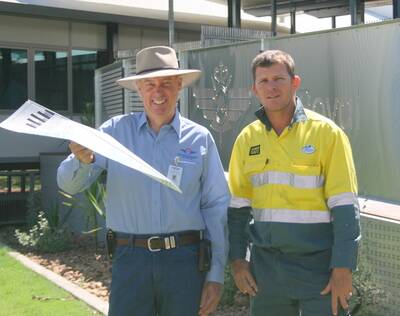FLYING ON: RFDS senior medical officer Don Bowley and Ergon's Darren Reddicliffe, with a paper plane made from an Ergon bill. - Picture: LIZ MACINTYRE/2550