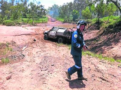 BOGGED: Co-pilot of the helicopter rescue service Brett Knowles cracks a smile over how deeply the Nissan is bogged.