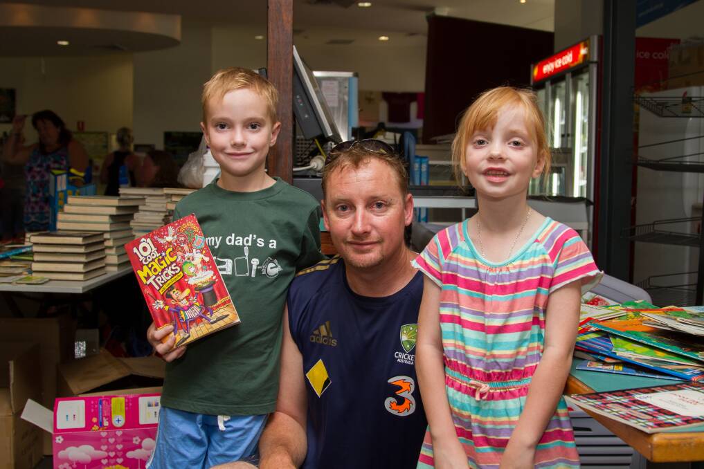 FAMILY TIME: Laurie Morrissey helped his children Lachlan and Charolette pick out a book to support flood victims.