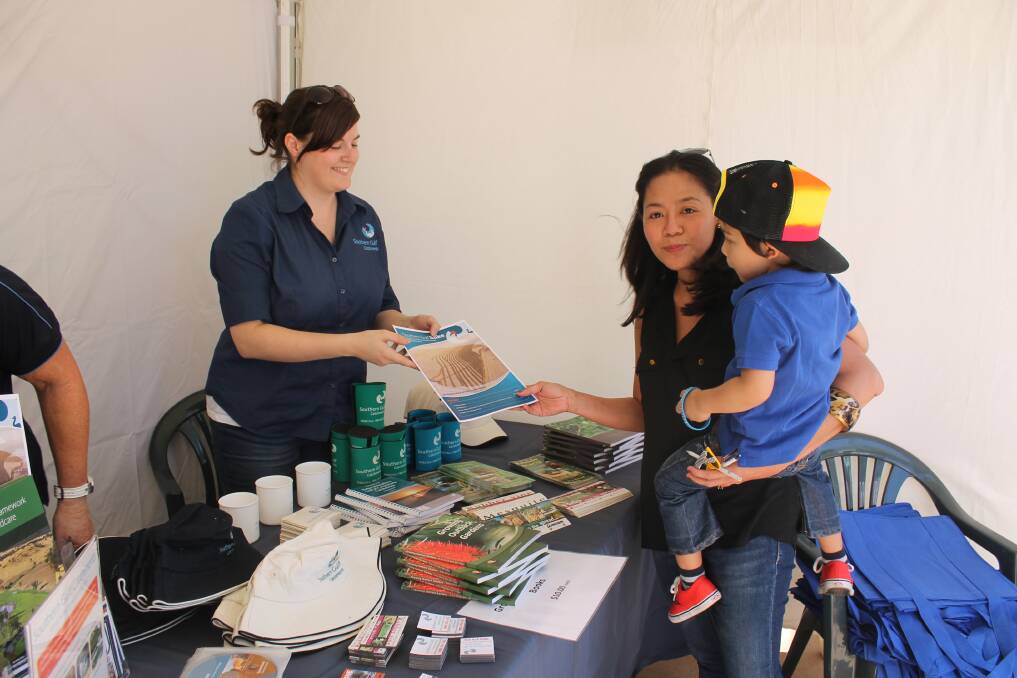 INFO: Laura Parkinson from Southern Gulf Catchments hands some information to Rowena Von Nida and her son Tyson, 3.