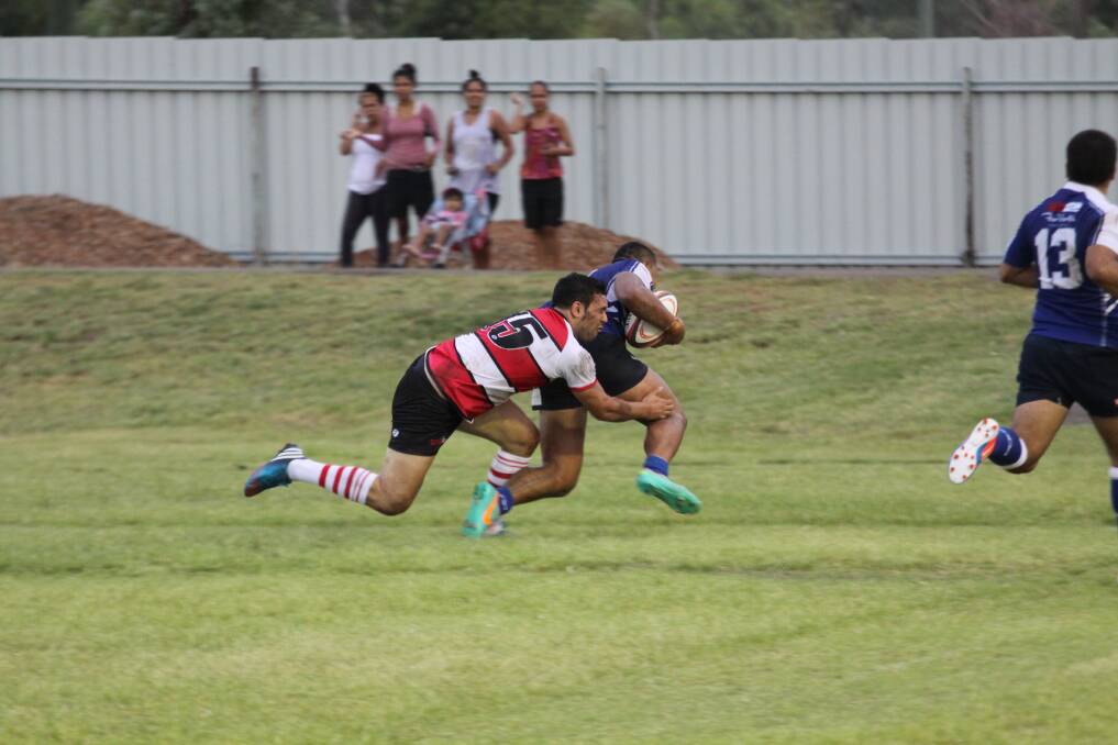 DESPERATION: Eli Sweeney tries to stop Cairns Esera Faaofo from scoring.