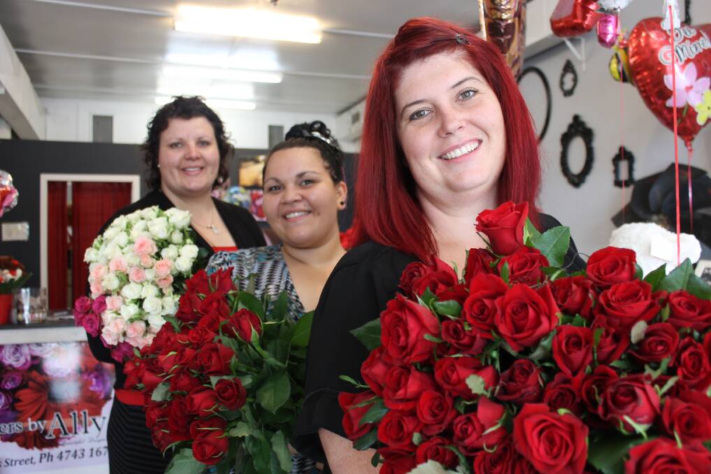 ROMANTIC ROSES: Flowers By Ally florist Ally Harris and staff Larissa Backo and Vanessa Baxman show off bunches of their quickly dwindling supply of red roses. - Picture: HAILEY RENAULT/4504