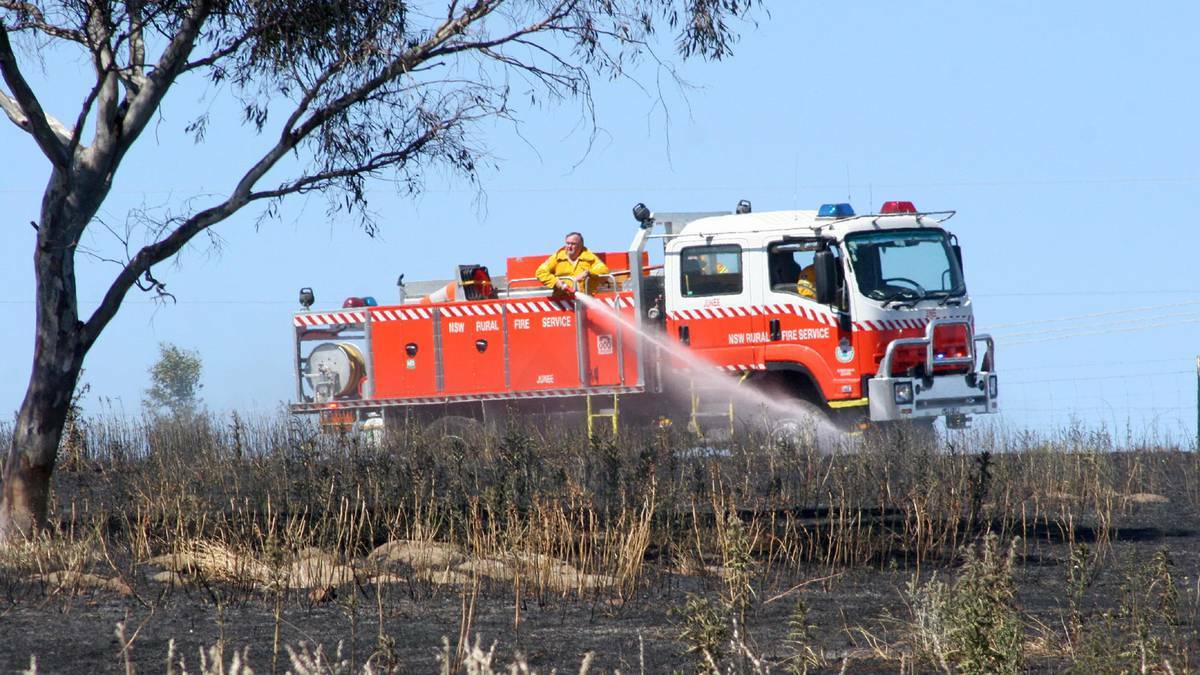 Firefighter mop up a blaze in a Junee paddock, near Wagga in NSW, caused by a tractor slashing grass. Picture: Declan Rurenga