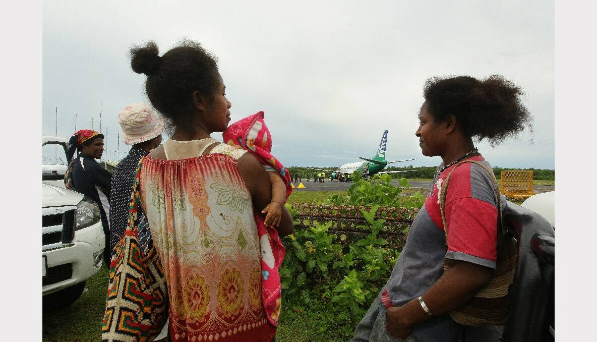 Manus Island women come to watch the asylum seekers arriving on Manus Island in Papua New Guinea. This is the second plane in two days bringing asylum seekers to Manus Island. Photo: Kate Geraghty