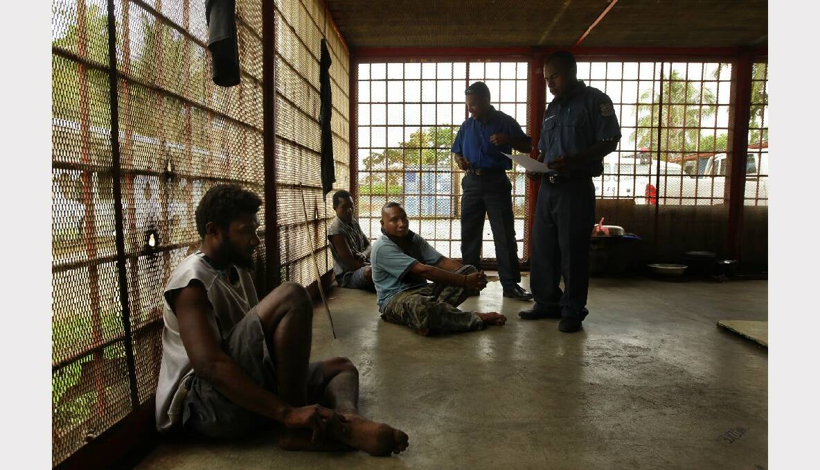 Members of the Manus police force talk to prisoners in the Lorengau police station cell block. This is the same prison cell block where 21 year old Raymond Sipaun died from injuries after being bashed by the Mobile Squad on Manus Island, Papua New Guinea. Photo: Kate Geraghty