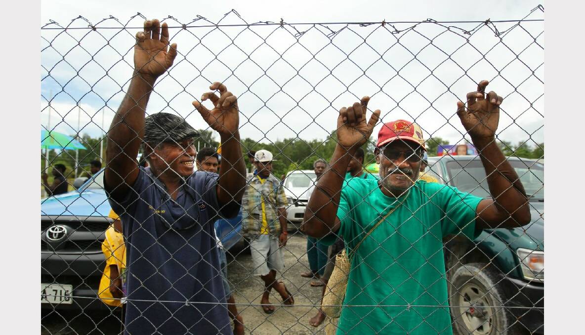  Local Manus Island residents watch the arrivals from a flight from Port Morseby at the airport on Manus Island in Papua New Guinea. Photo: Kate Geraghty