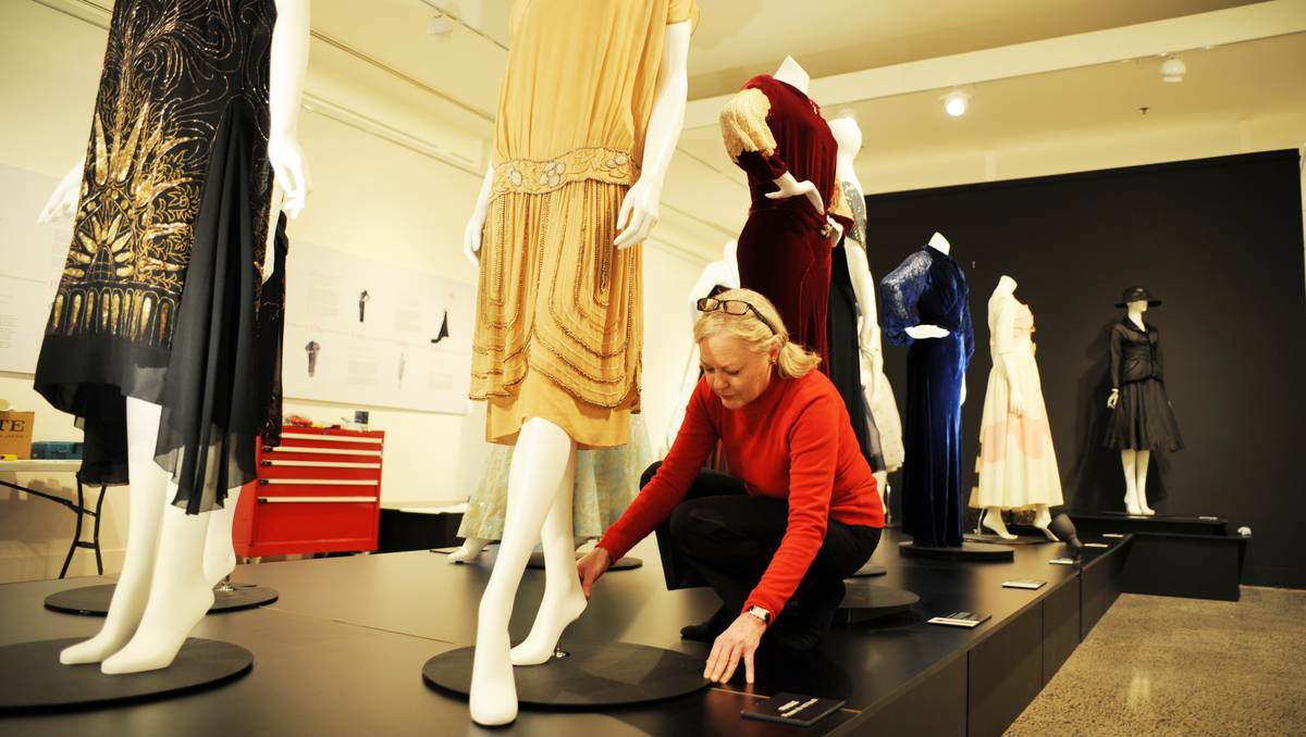Acting curator Robina Booth puts the final touches on After Five Fashion from the Darnell Collection, which opens tonight at the Bathurst Regional Art Gallery. Picture: Zenio Lapka.