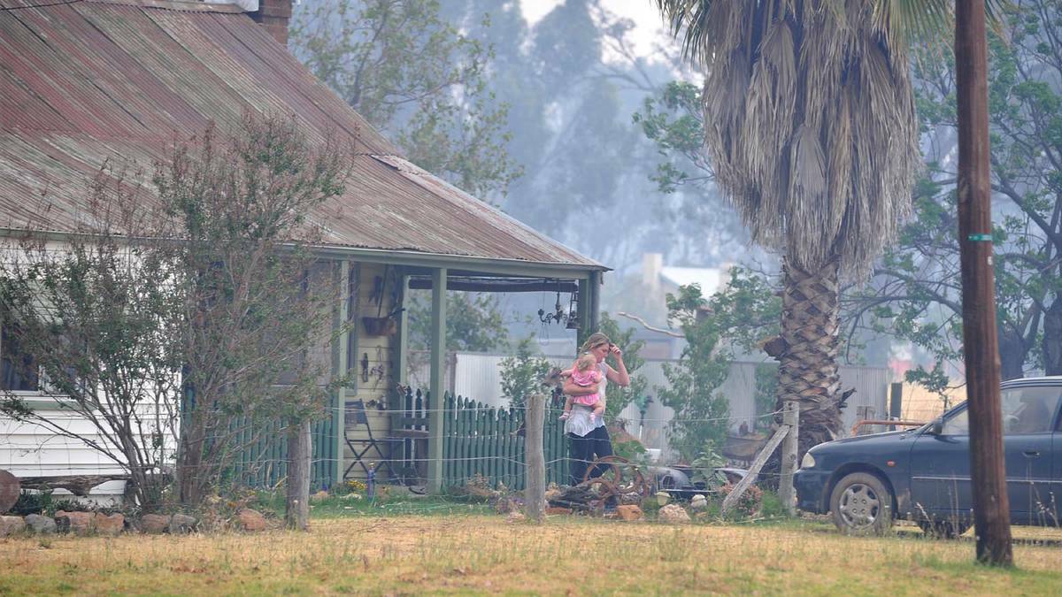 A Stockinbingal resident evacuates as the blaze approaches the township of Stockinbingal. Picture: Michael Frogley