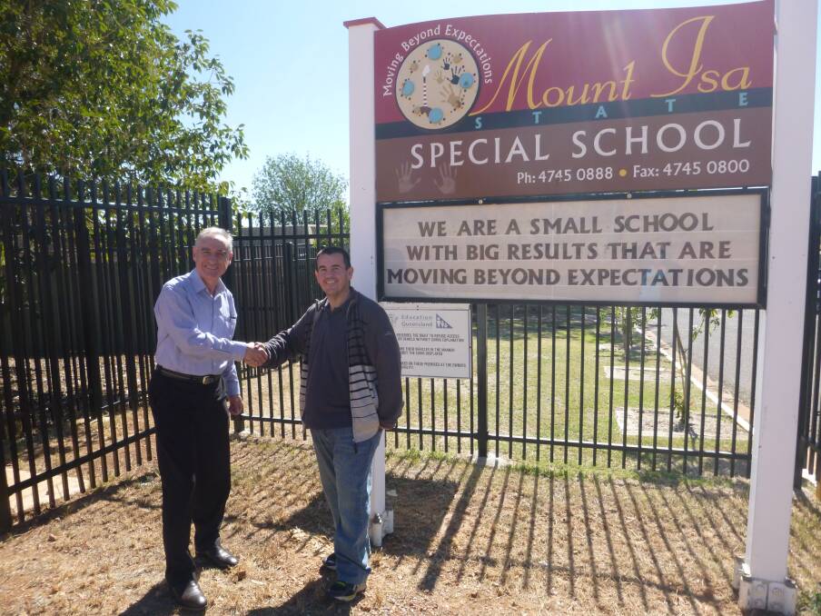 Reno Tieppo and Geoff Miller in front of the Mount Isa Special School sign.