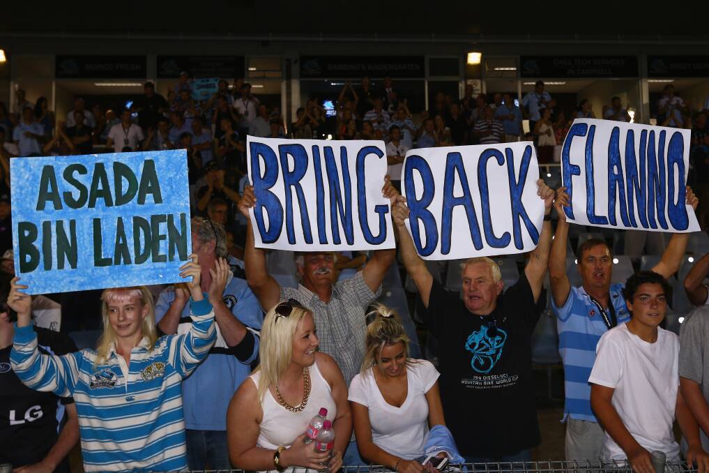 Sharks supporters hold up a signs in support of the Sharks coach Shane Flannagan who was stood down by the club. Photo by Mark Kolbe/Getty Images