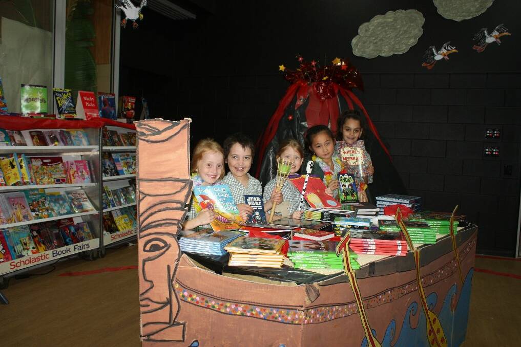 COLOURFUL DECORATIONS: Shekinah Coady, 8, San-San Huang, 7, Elizabeth Elliott, 7, Will Calrand, 7, and Shannon Harvey, 7, show off some books available at this year's St Joseph's Primary School book fair on board a HawaIian vessel near the volcano. - Picture: CHANELLE SZMOLNIK