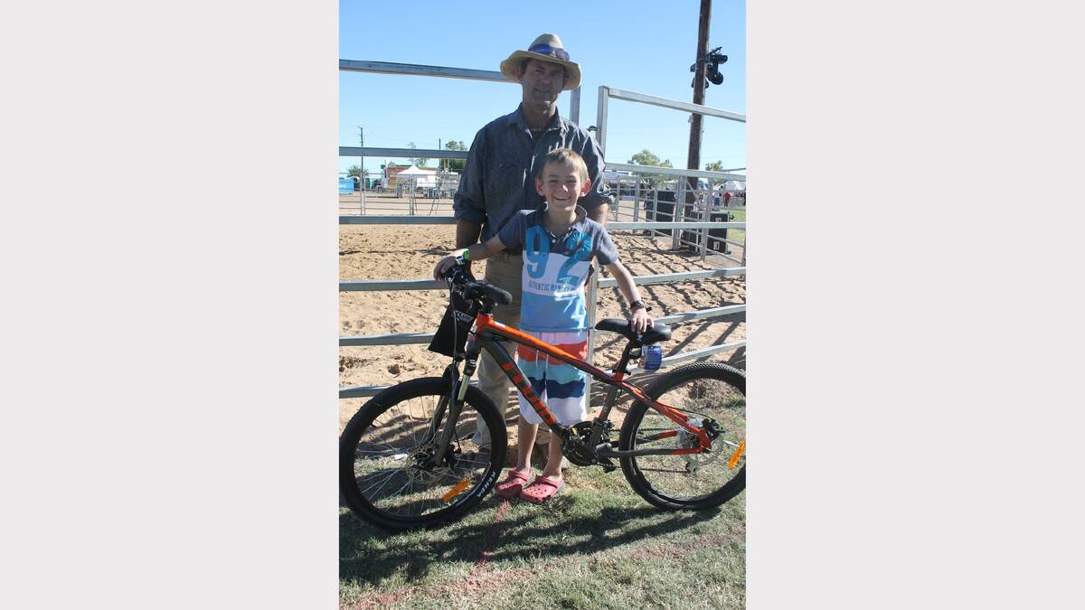 LUCKY BOY: Cody Wockner, 8, won a bike in the lucky door prize sponsored by Anaconda. His father Clint could hardly keep his son from riding around the arena in excitement.