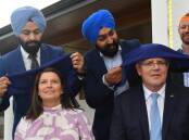 Prime Minister Scott Morrison and wife Jenny get their headscarves at Perth Sikh Gurdwara. Picture: AAP