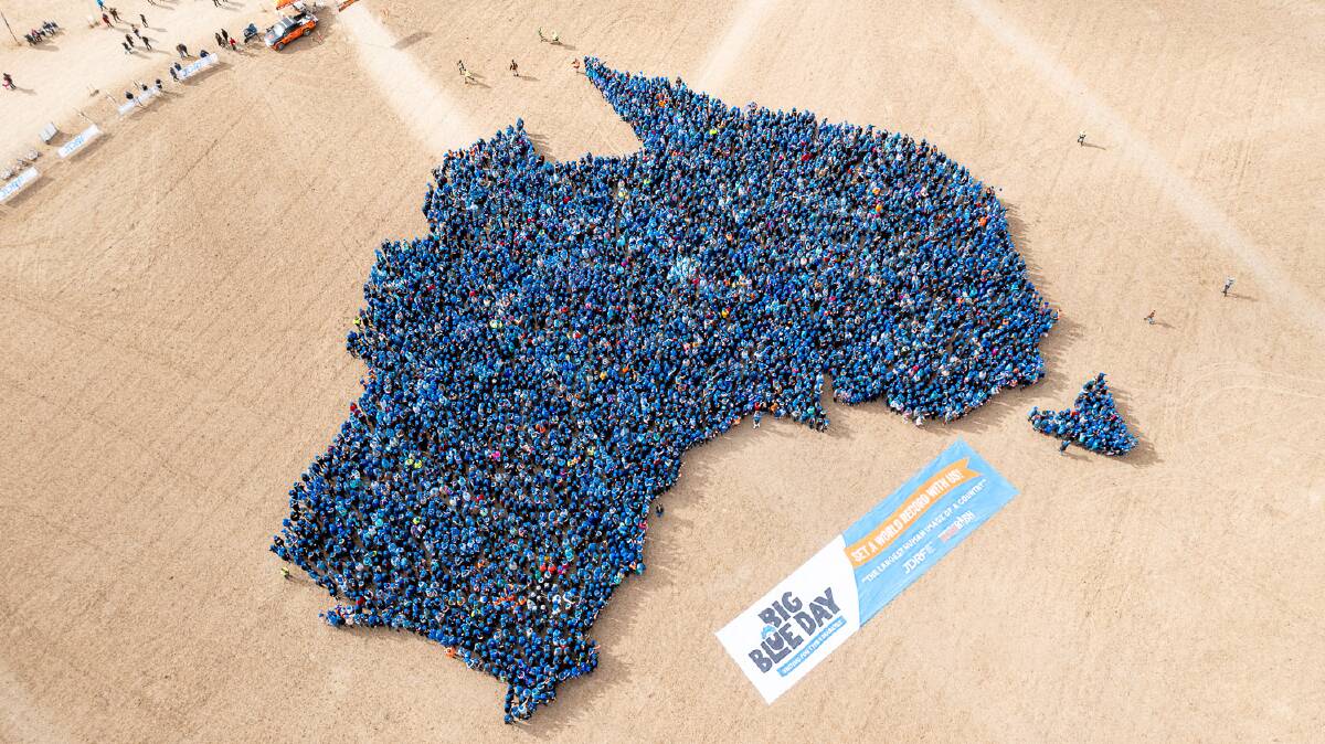 More than 5,000 punters dressed in blue gathered to break the world record for the largest human image of a country. Picture Matt Williams.