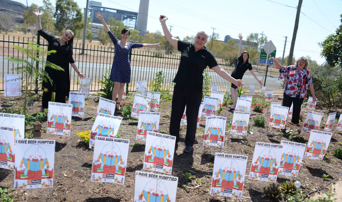 ASSEMBLING THE HUMPTY DUMPTIES: The Mount Isa LJ Hooker team includes Amelia Steele, Sherrie Tuppurainen, Ranita Toholke, Jenny Logan and Kim McKelvie. They place the Humpty Dumpty posters in the Blue Care lawn. Photo: Chris Burns. 