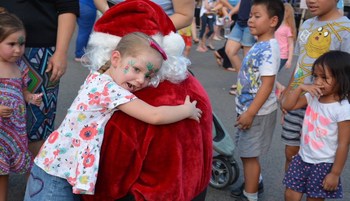 BIG HUG: Bree Contarino, 4, gives Santa Claus a big hug for all the good work he has done. Photo: Chris Burns. 