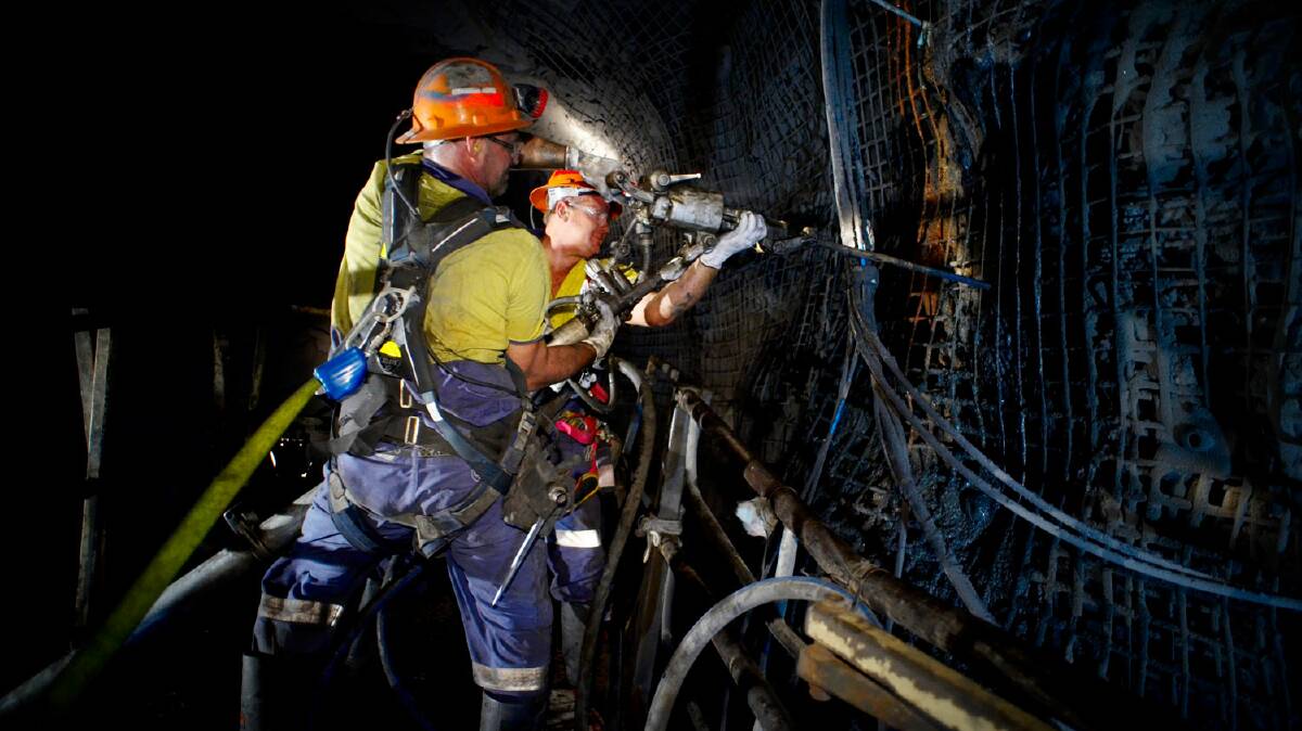 On shift: A drilling crew secure a ground stabilisation rock bolt at George Fisher mine. Photo: Mount Isa Mines