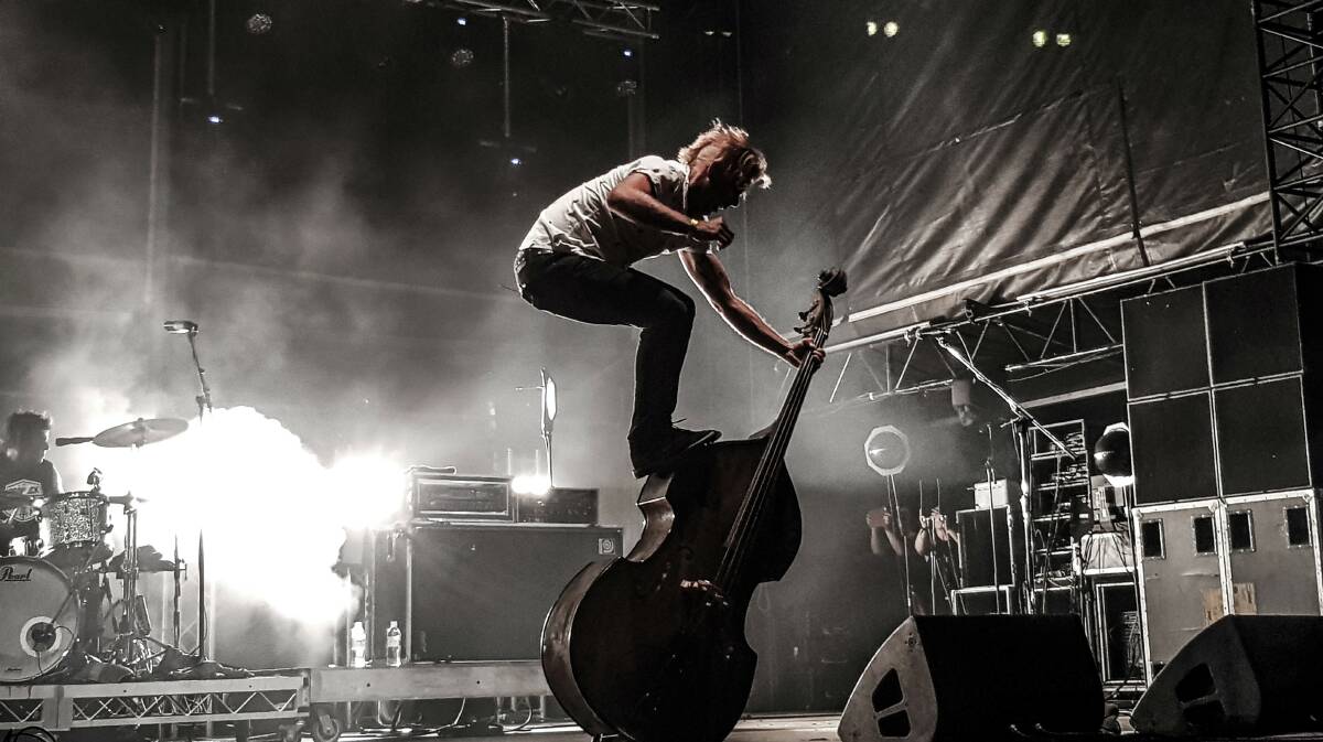 Living End double bass player, Scott Owen, and one of his trademark moves. Photo supplied by Winton Shire Council.