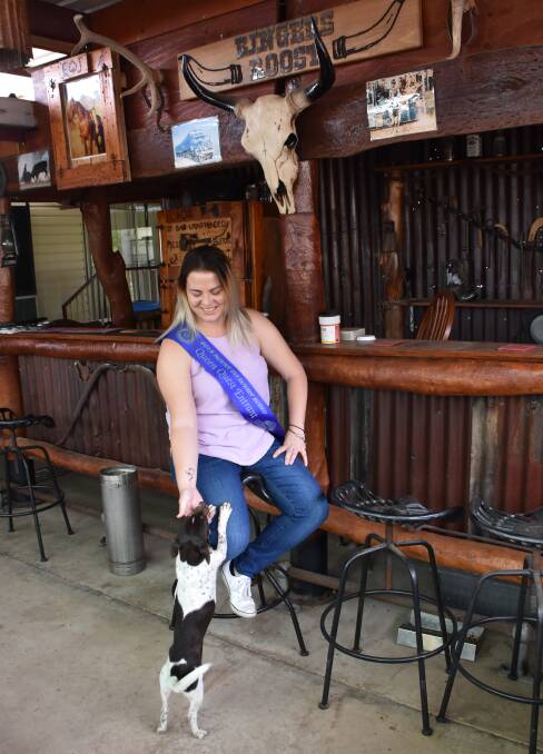 Tegan at her Dad's rodeo bar, with one of the family pups.