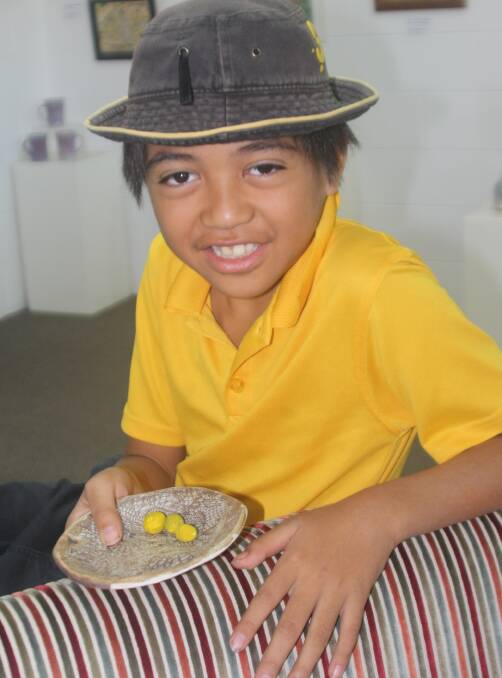 INSPIRING ART: Harley Leicht (10) holding a piece from the Sunset State School pottery exhibition at Arts on Alma, Mount Isa. Photo: Esther MacIntyre