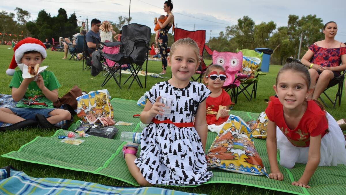CHRISTMAS PICNIC: Rory (6), Olivia (6), Emilyn (4), and Ava (5) sit down to sizzling snags and goody bags, at Mount Isa Mines' Christmas party. Photo: Esther MacIntyre